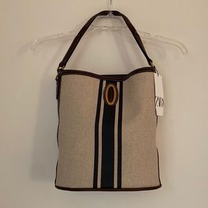 Bucket bag from Zara with fabric exterior and front metal detail.